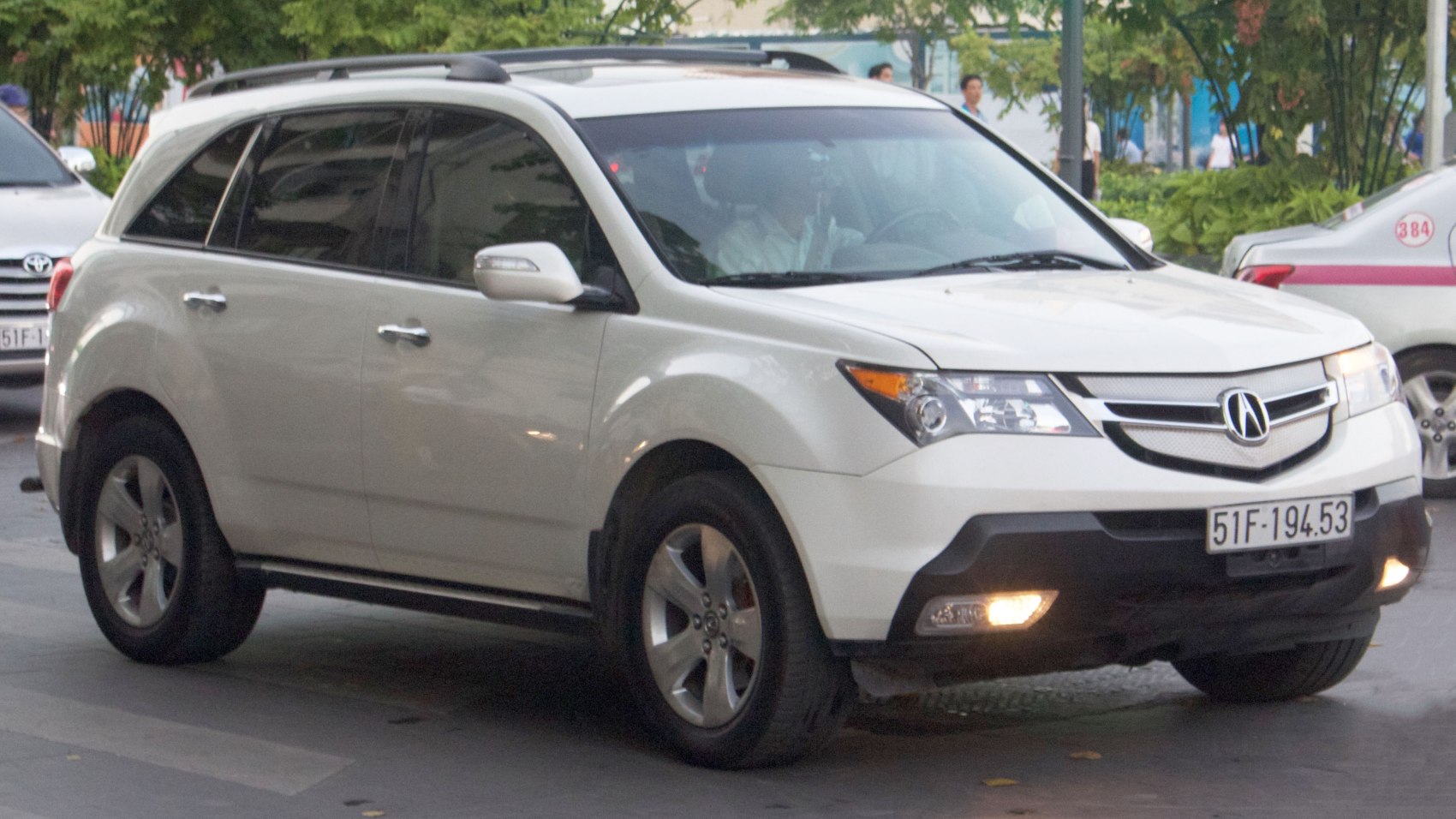 Front side view of SUV with headlights, grille, and alloy wheels