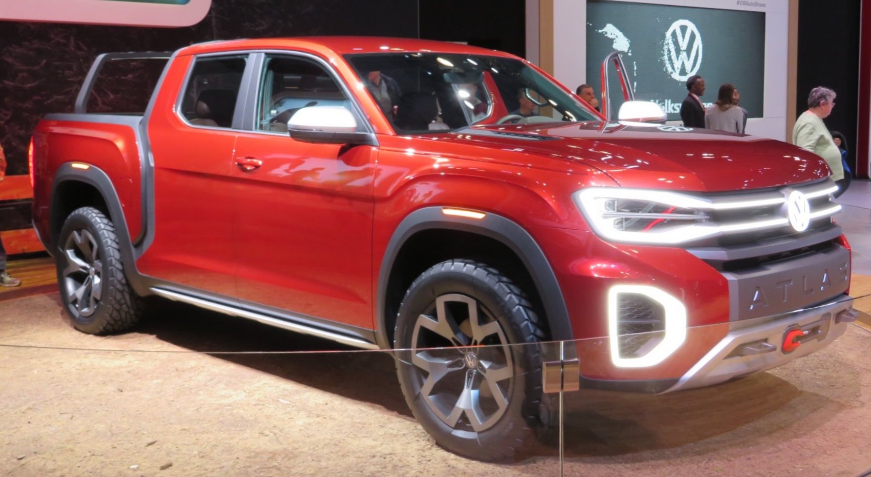 Red pickup truck with bold LED headlights and rugged styling.