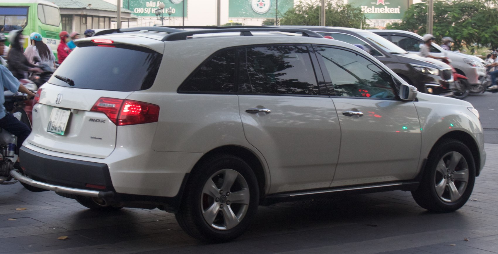 Rear side view of white mid-size SUV with alloy wheels and roof rails