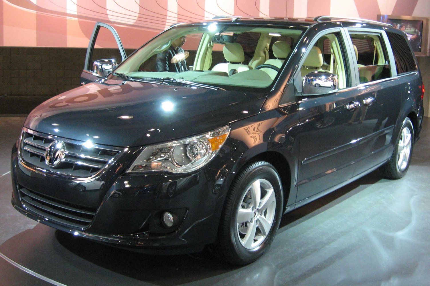 Front view of minivan with open driver door and chrome side mirrors