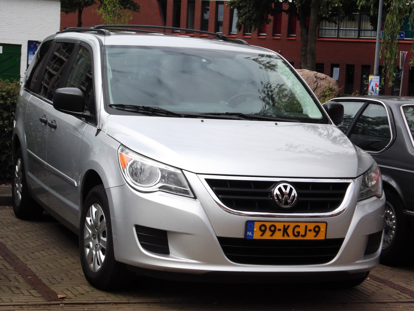 Silver minivan front and side view with grille and roof rails