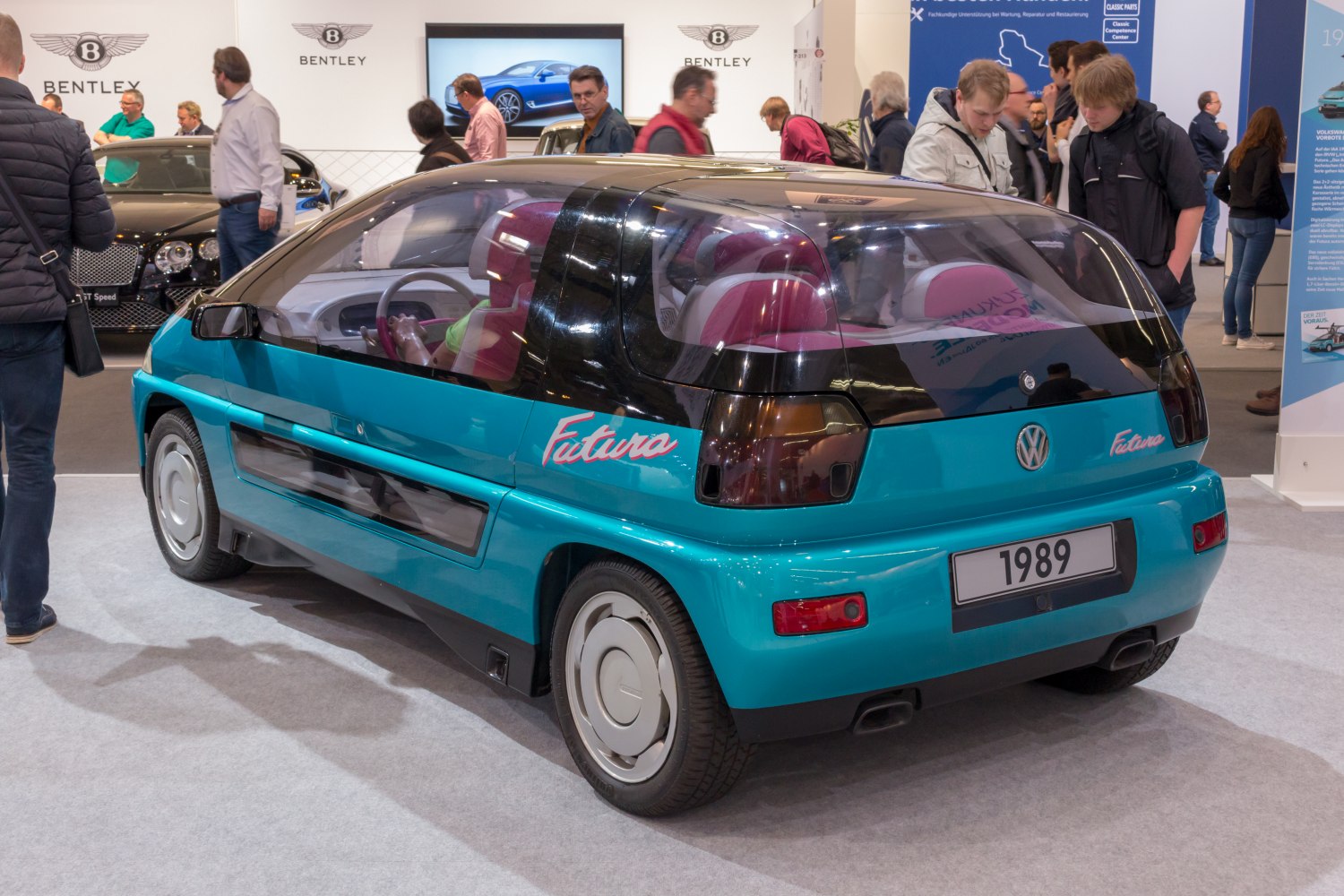 Teal futuristic hatchback with transparent rear and unique rear design.