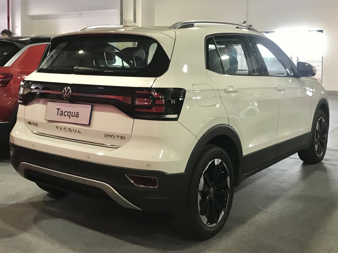 Rear profile of a modern white SUV with distinctive taillights and roof rails