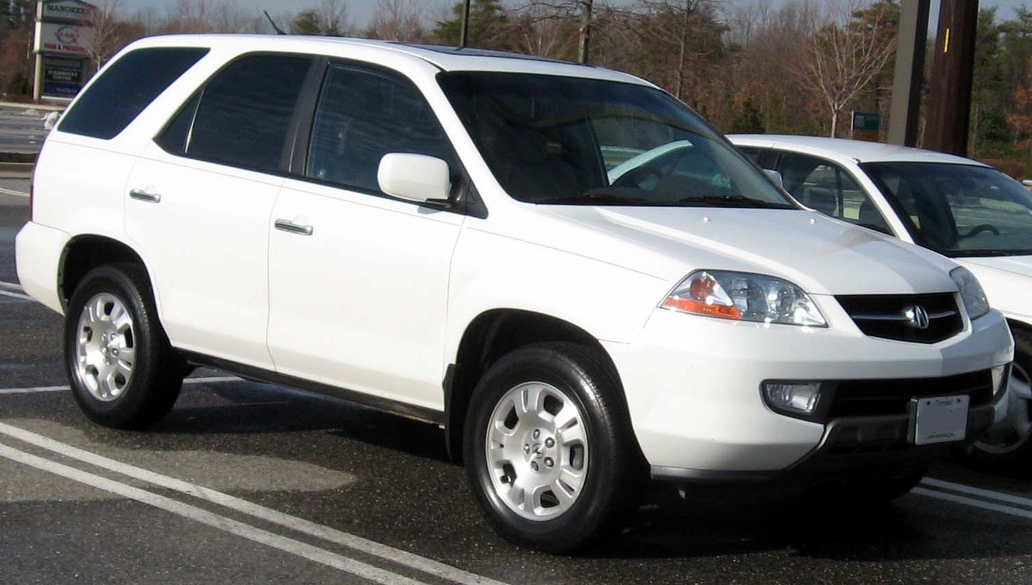 Front side view of a white SUV with alloy wheels and prominent headlight design