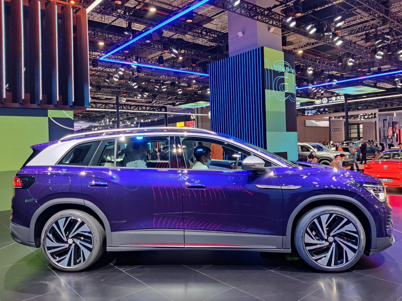 Side profile of electric SUV with large alloy wheels at auto show