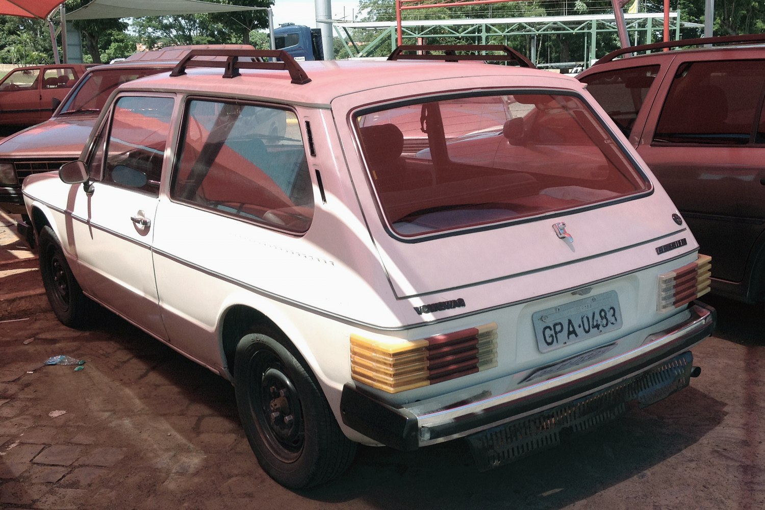 Rear angled view of 3-door hatchback with roof rack and rectangular taillights