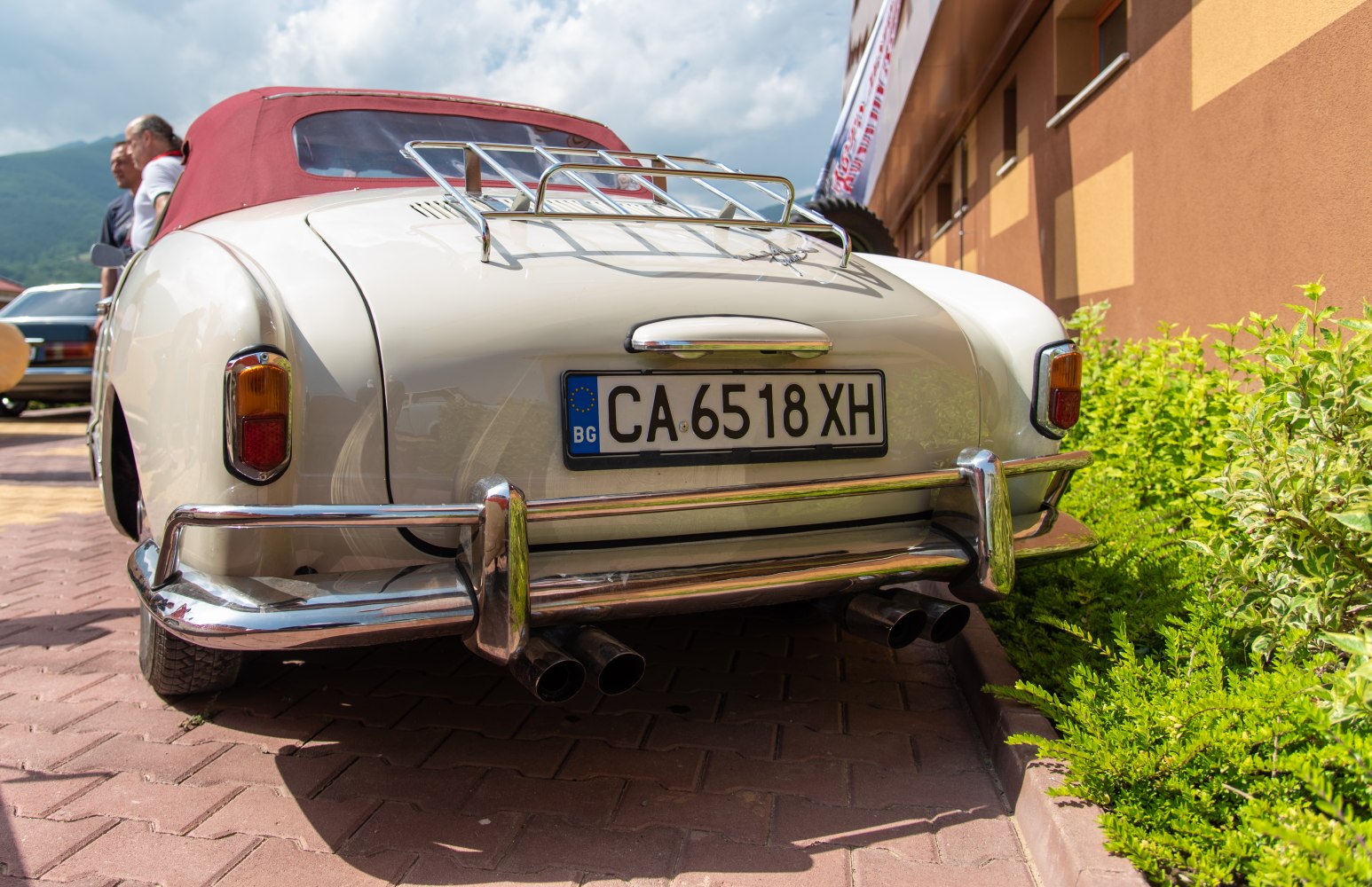 Rear convertible with chrome luggage rack and dual exhaust pipes.