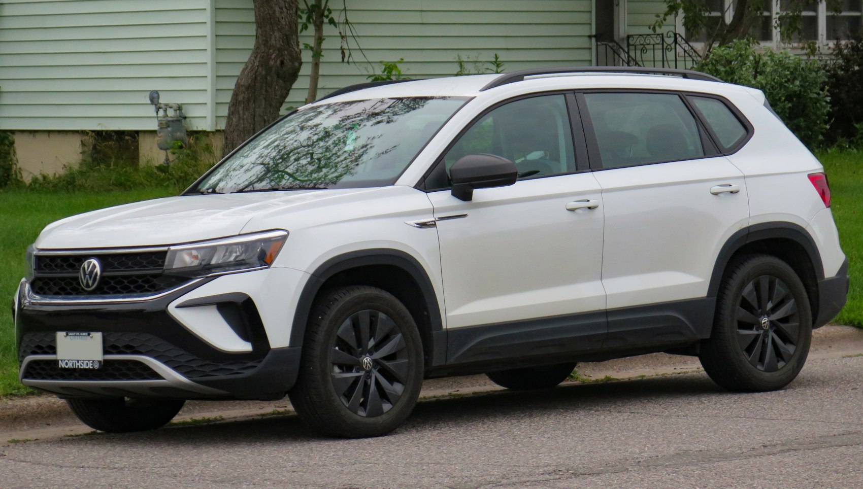 Side profile of white SUV with black wheels and roof rails