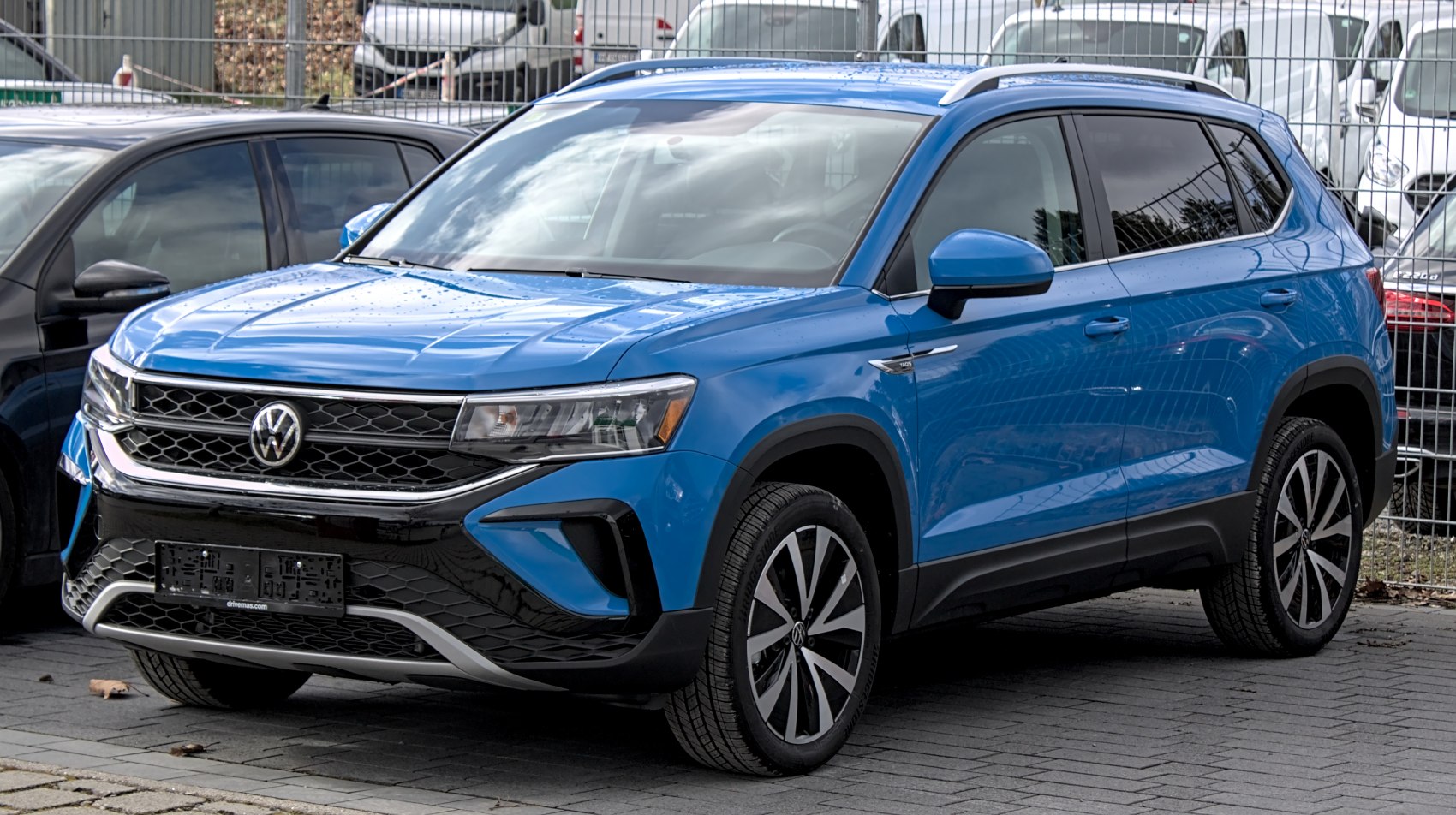 Front right angle view of blue SUV with prominent grille and alloy wheels