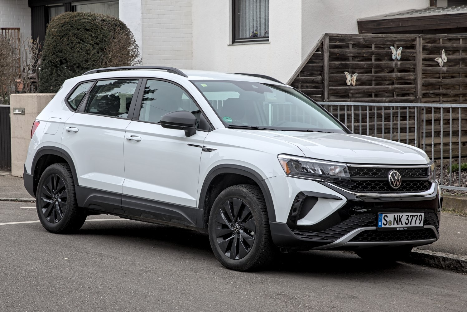 White SUV with black alloy wheels, front side profile.