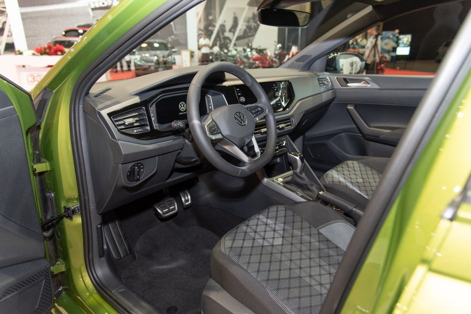 Digital dashboard and multifunction steering wheel with patterned front seats.