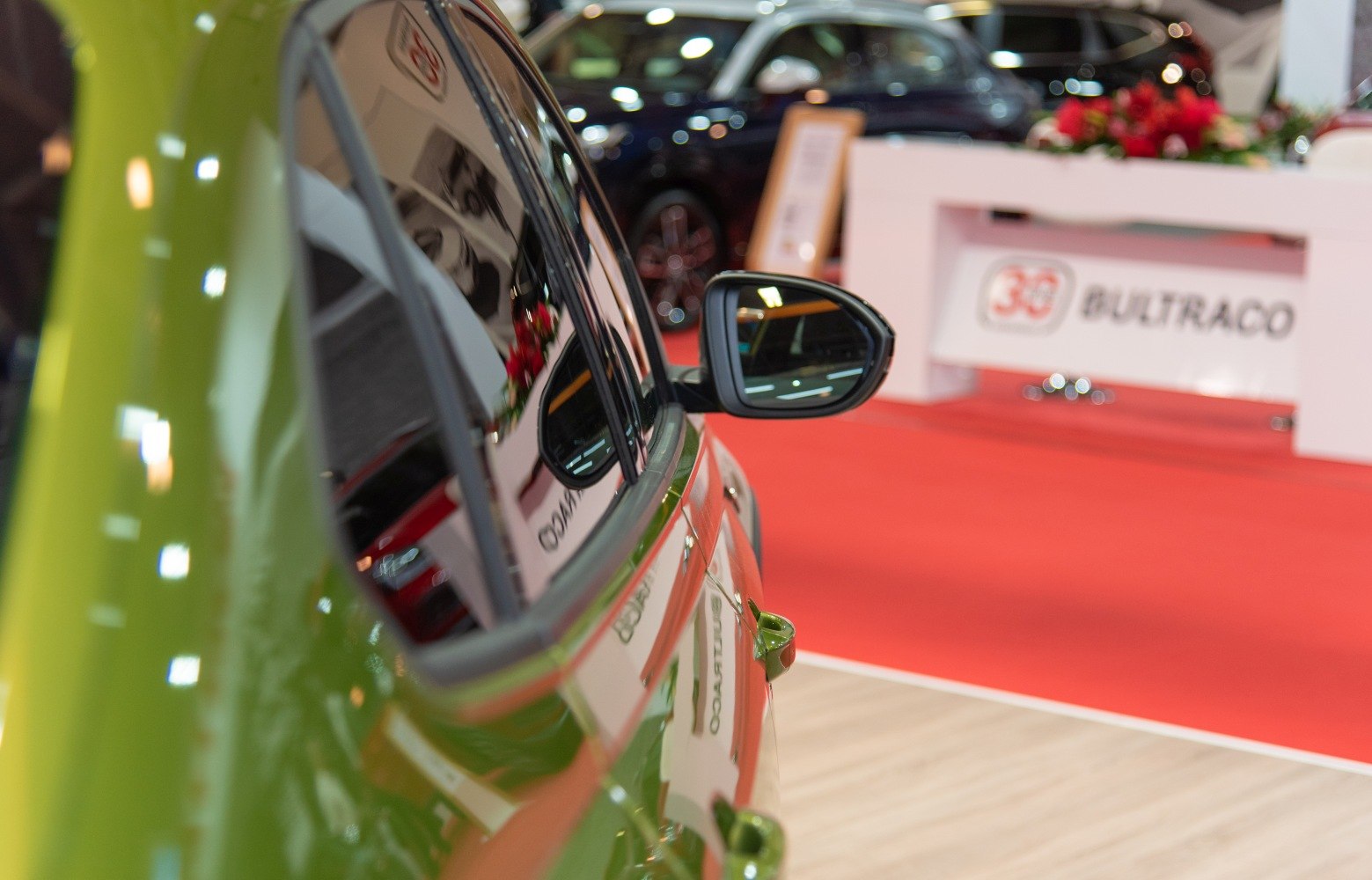 Close-up of green car side mirror and door handle