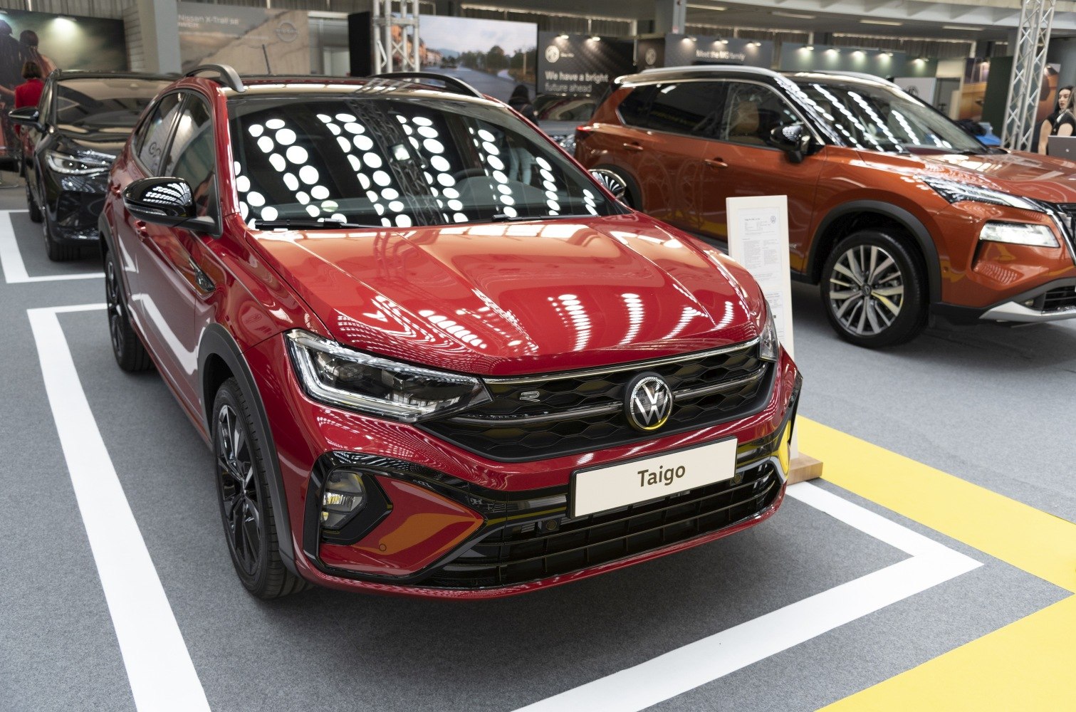 Front view of red car with LED headlights and black honeycomb grille