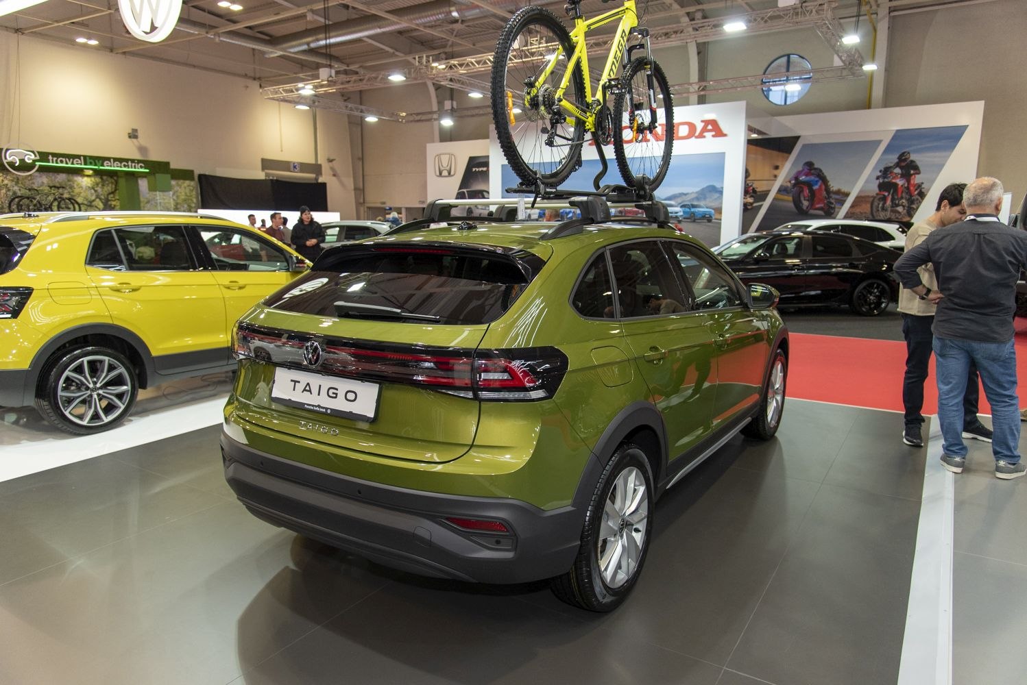 Rear view of green hatchback with roof-mounted bicycle