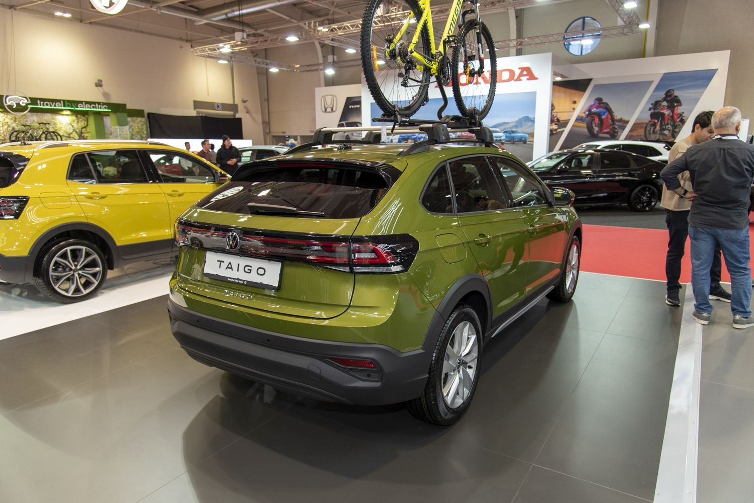 Rear view of a compact SUV with roof bike rack holding a yellow bicycle.