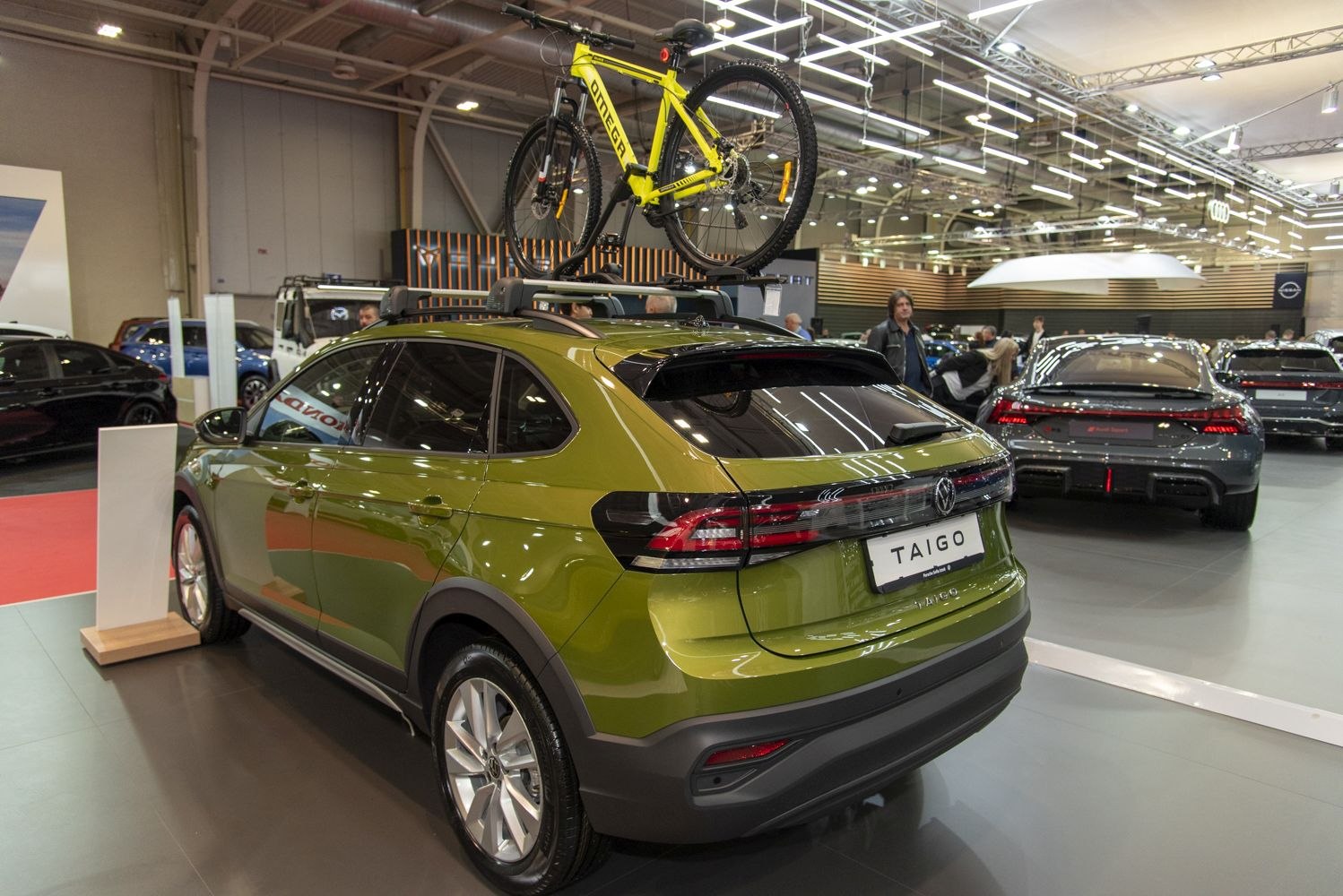 Green compact SUV with roof-mounted bike rack carrying bicycle