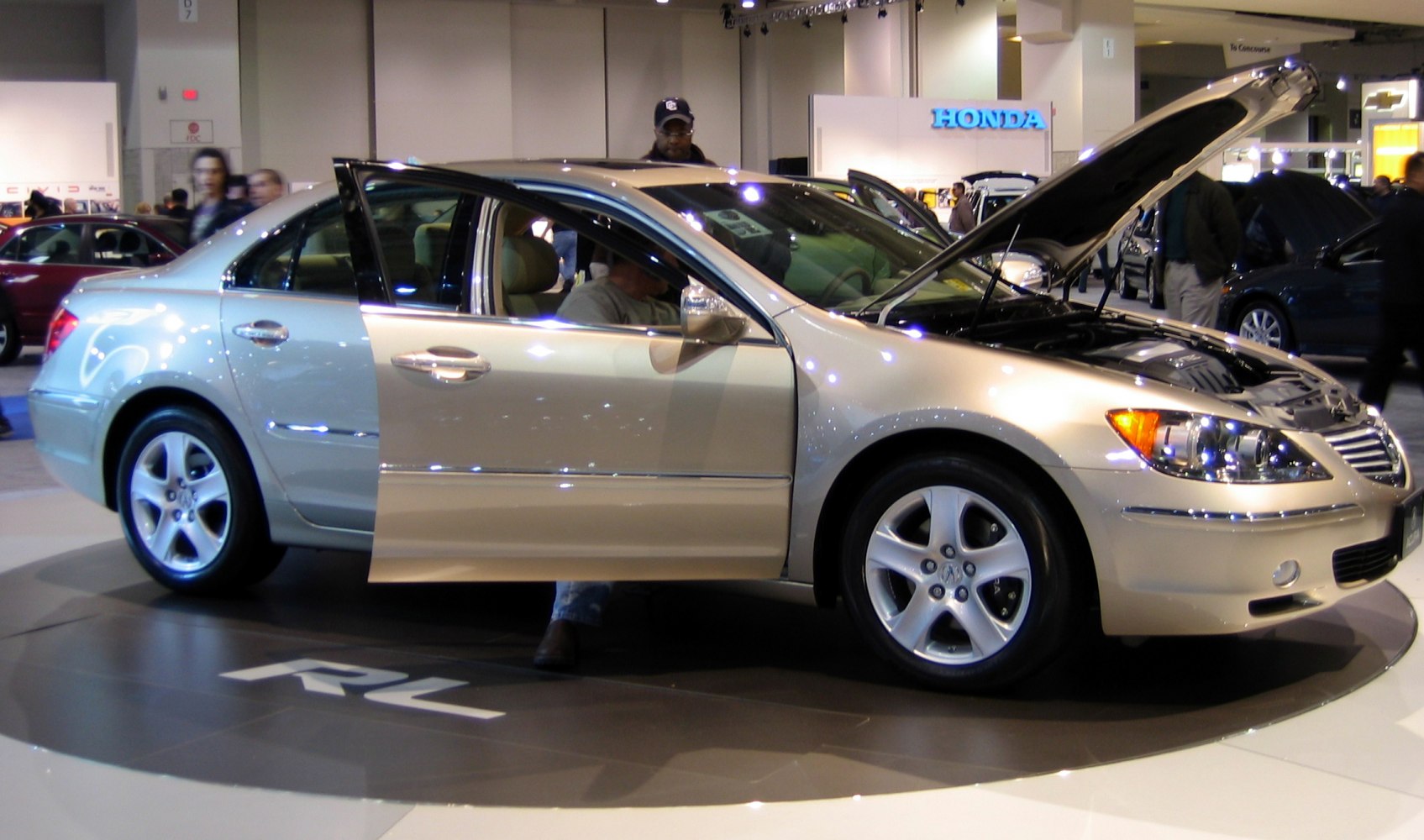 Luxury sedan with open front hood and rear door showcasing interior and engine bay.