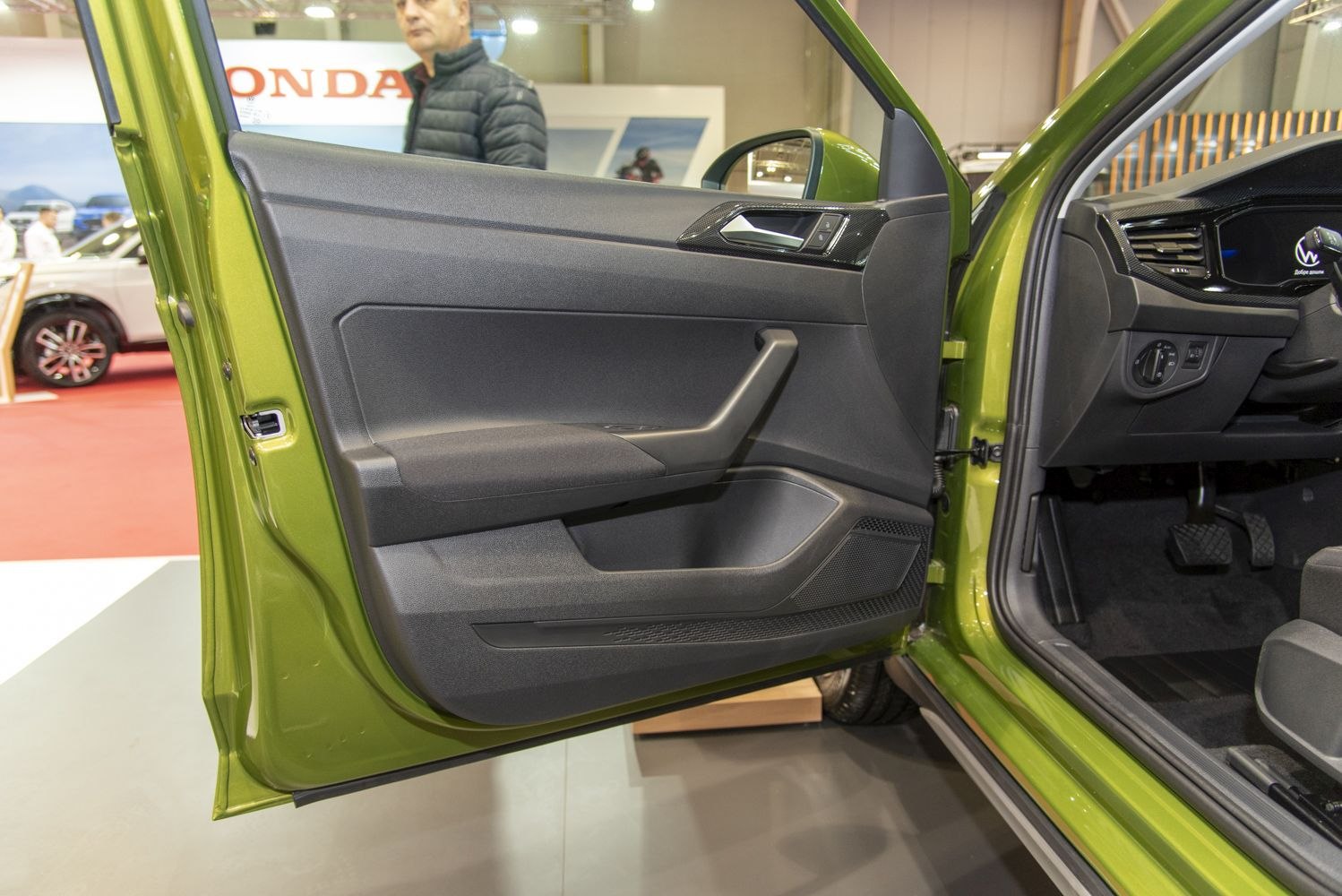 Ergonomic interior door panel with handle and speaker grille.