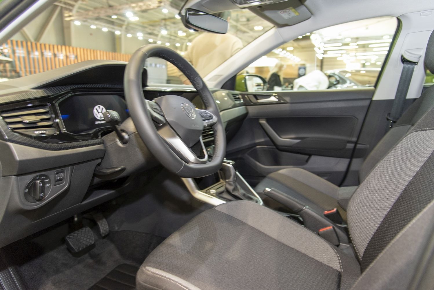 Digital dashboard and steering wheel inside a modern car interior.