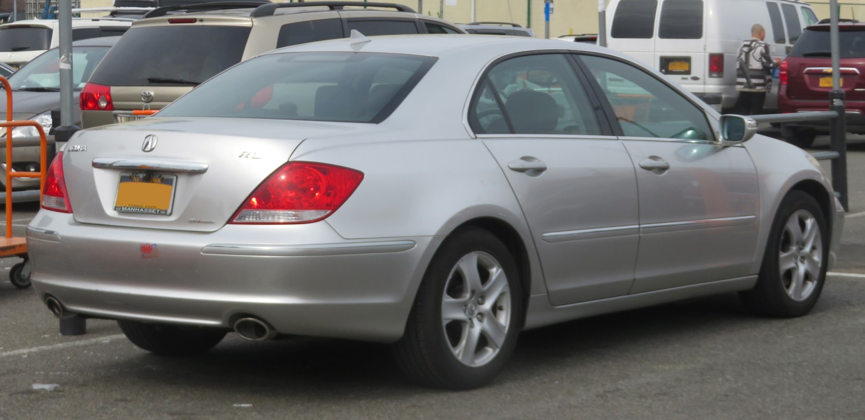 Sedan rear side view with dual exhaust and alloy wheels