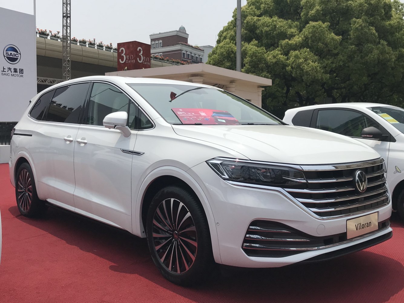 Front and side view of a sleek modern minivan with large grille and multi-spoke wheels