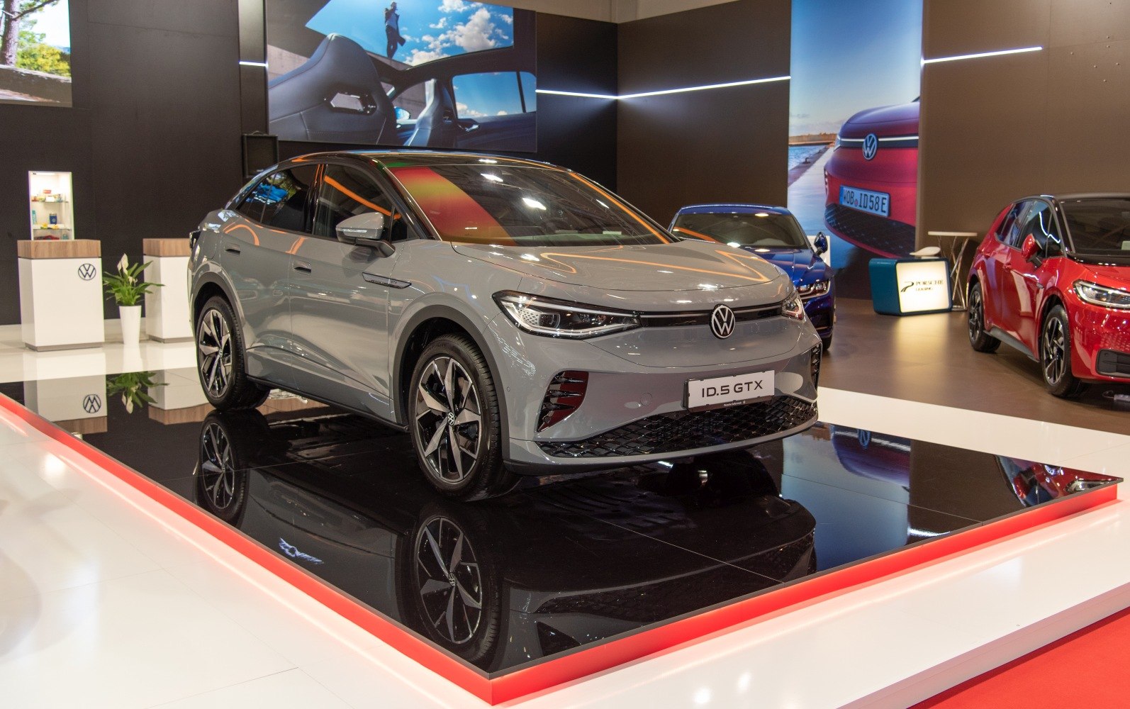 Modern electric SUV with aerodynamic body and LED headlights on glossy display platform