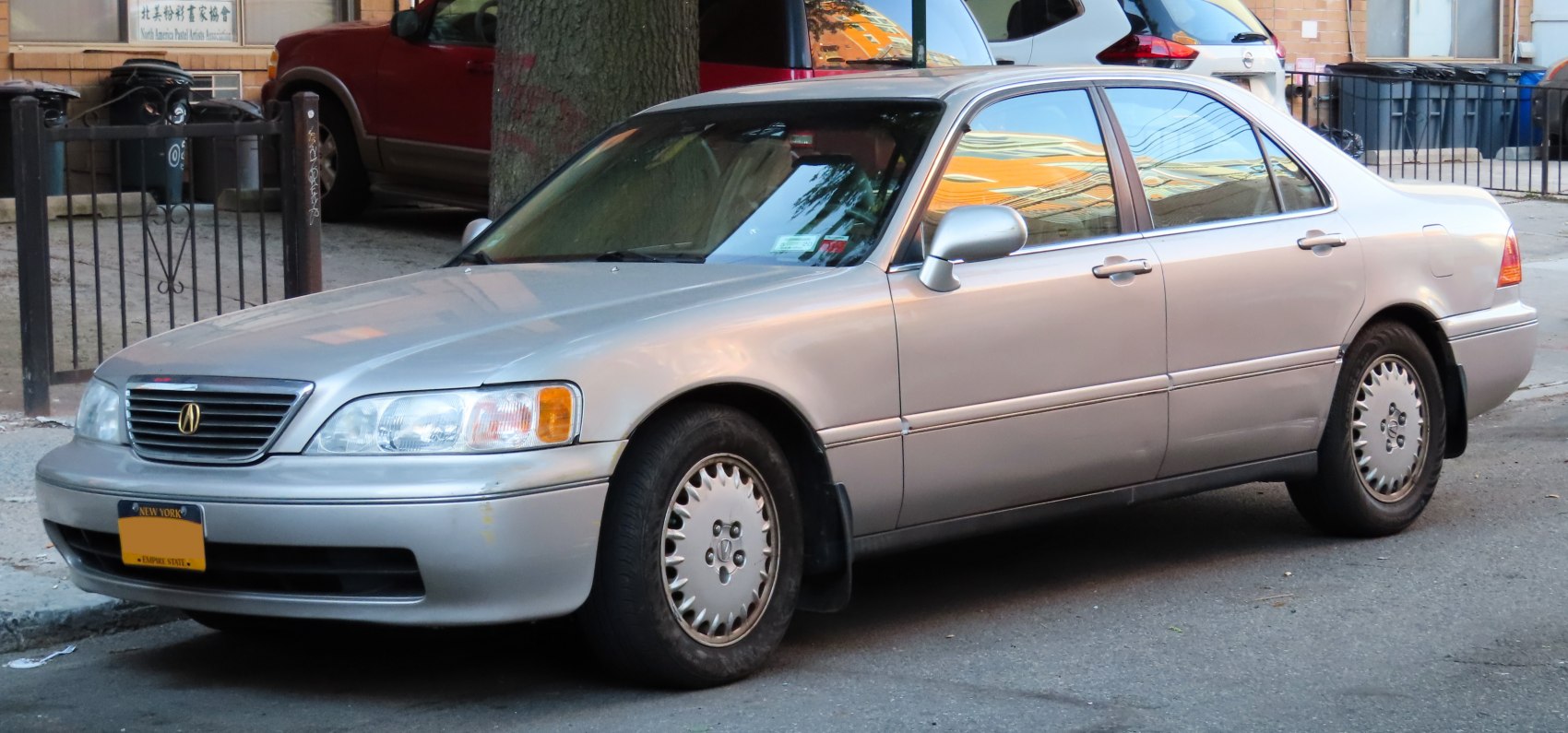 Front side view of a classic sedan featuring headlight, grille, and alloy wheels