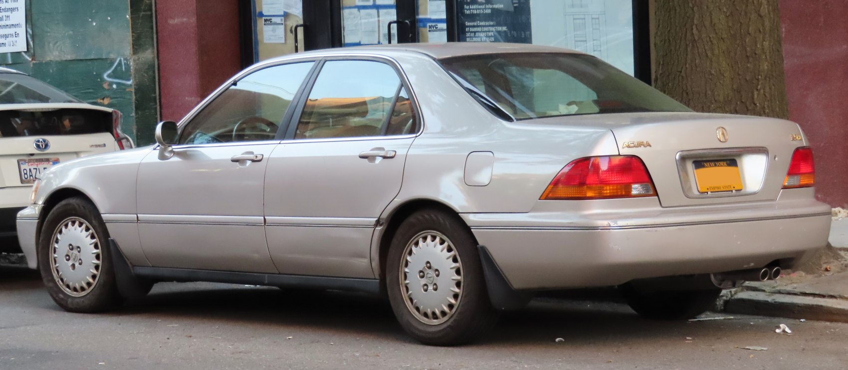 Silver sedan rear and side view with distinctive tail lights and alloy wheels