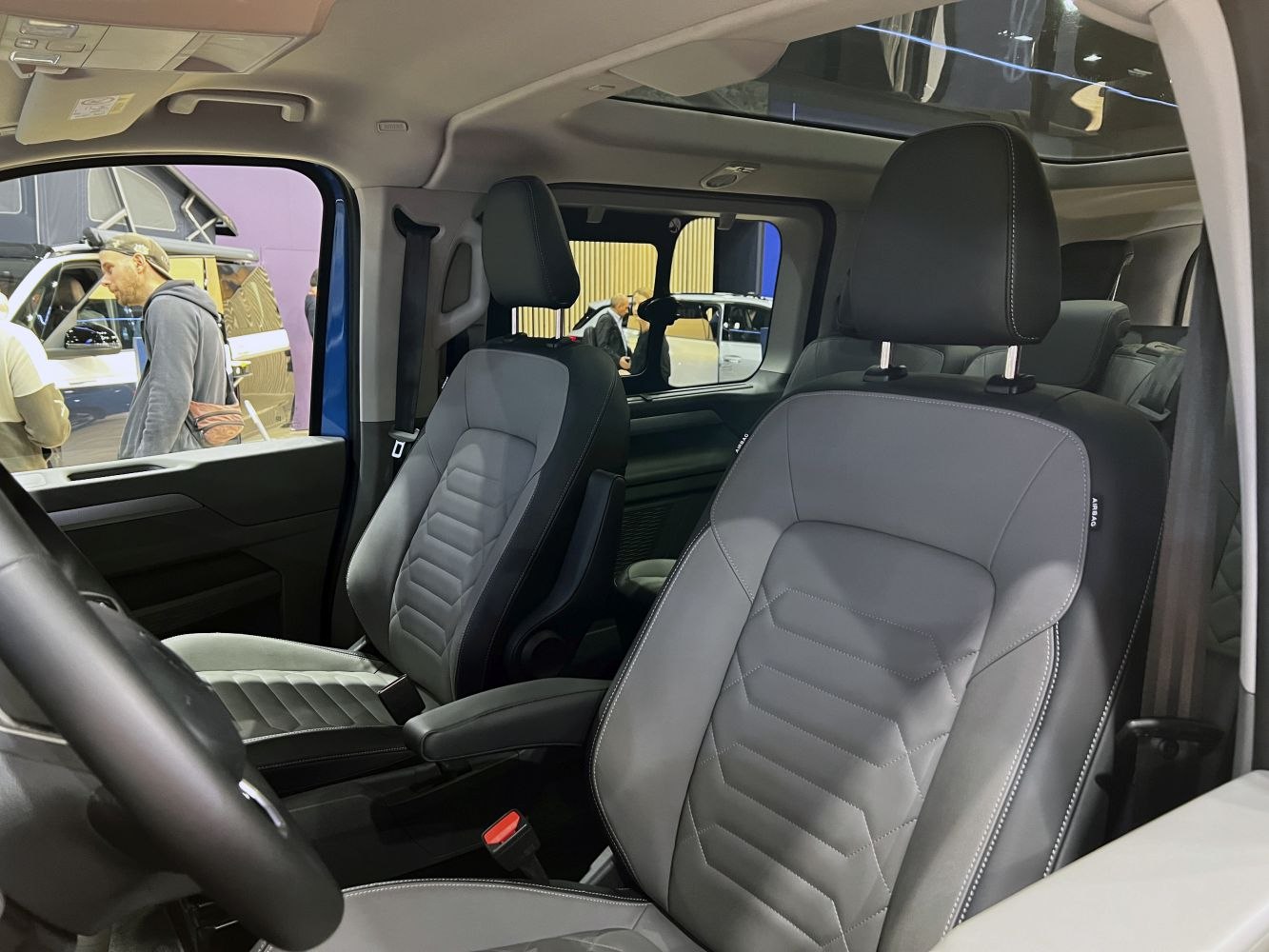 Leather front seats with modern stitching in spacious cabin