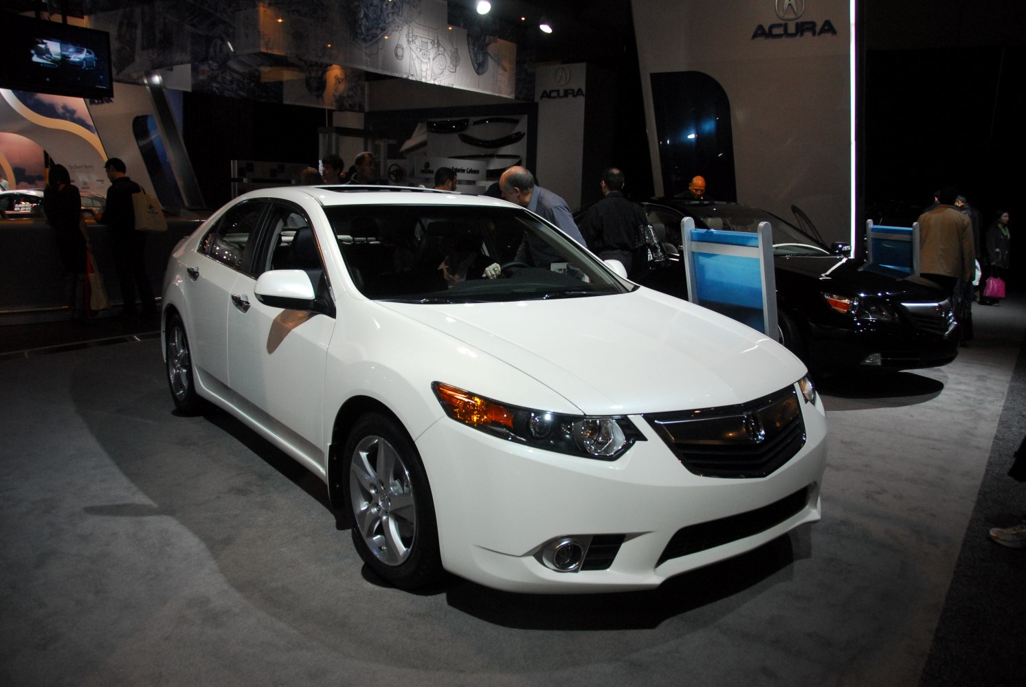 Front view of white sedan with alloy wheels and headlight details