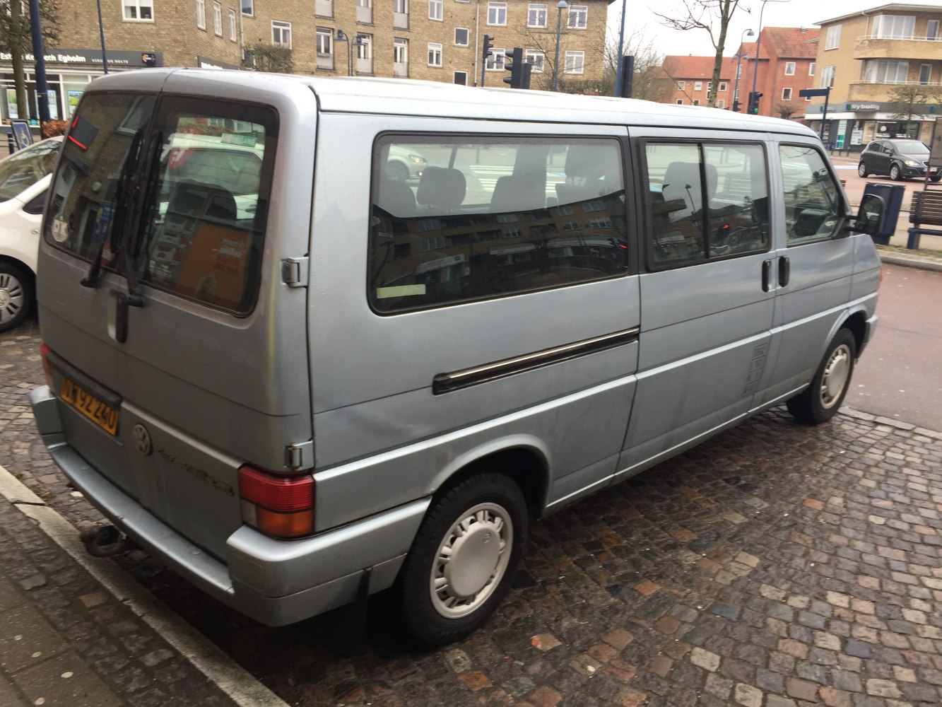 Rear side view of a vintage long van with sliding door and square tailgate