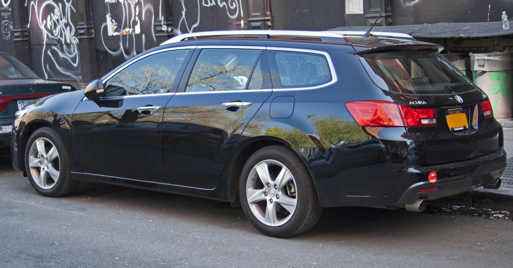 Rear-side view of a sleek wagon with alloy wheels and roof rails