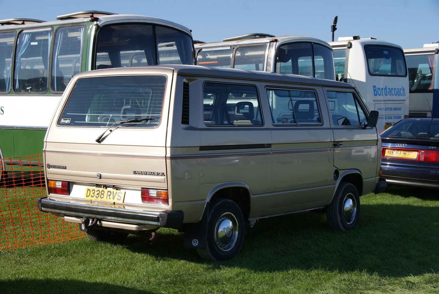 Rear view of a boxy vintage van with large tinted windows and steel wheels