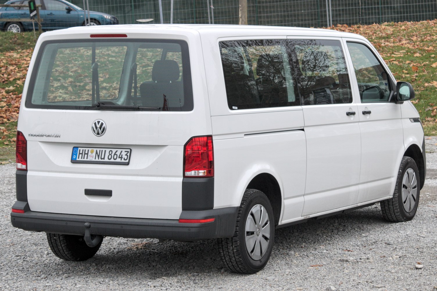 Rear and side view of white van with large windows and red tail lights