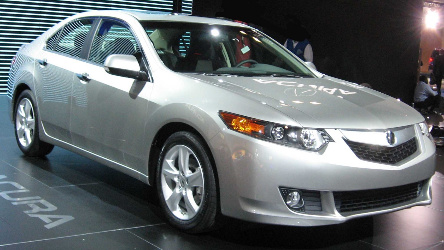 Silver sporty sedan front view with alloy wheels and distinctive grille