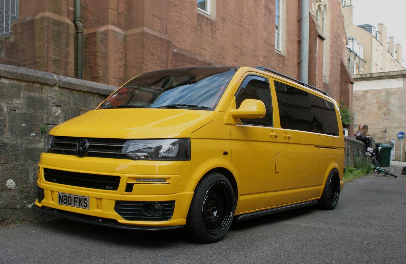 Yellow lowered van front side view with black wheels and tinted windows