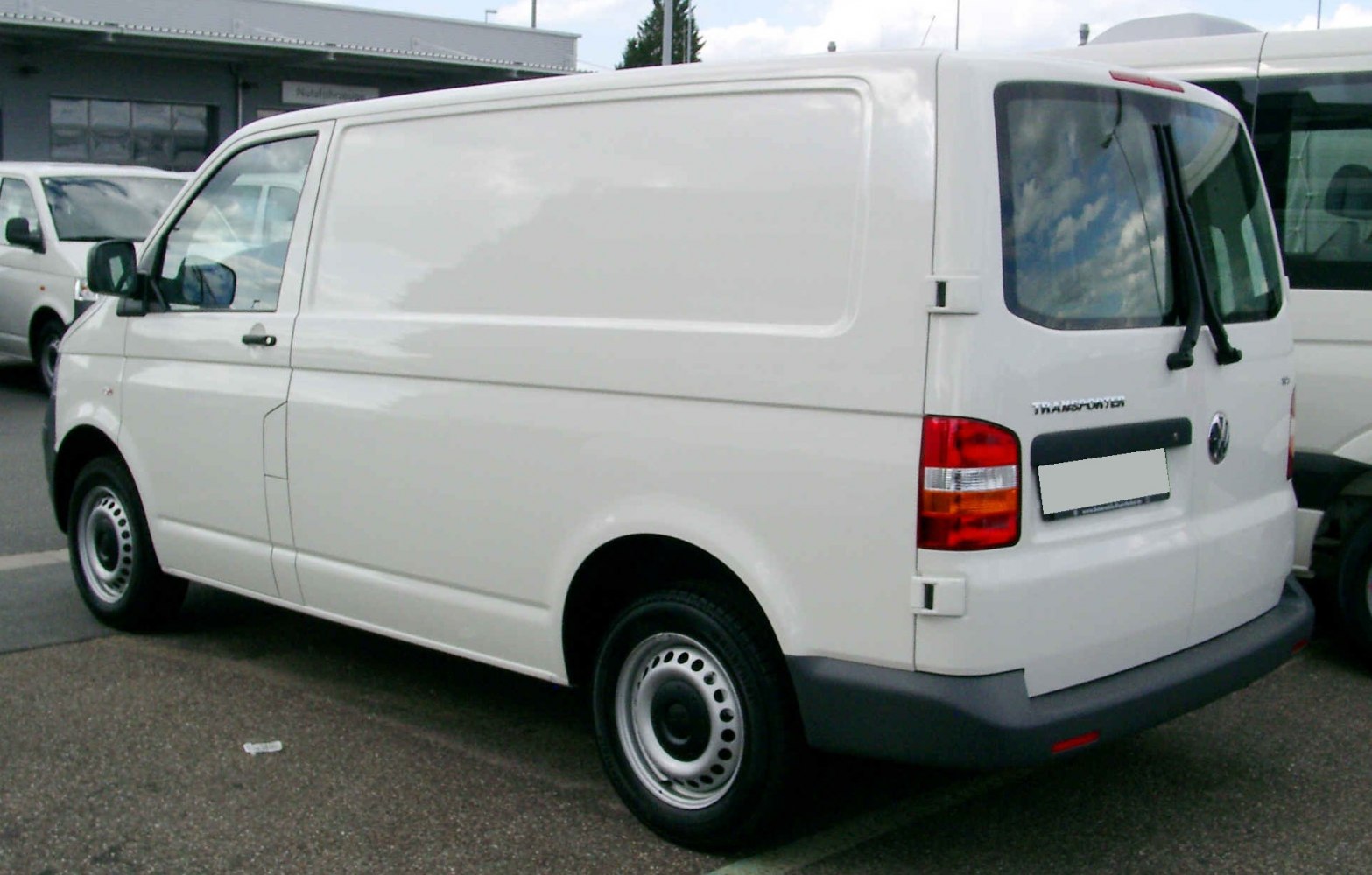 White panel van rear side view with sliding door and steel wheels