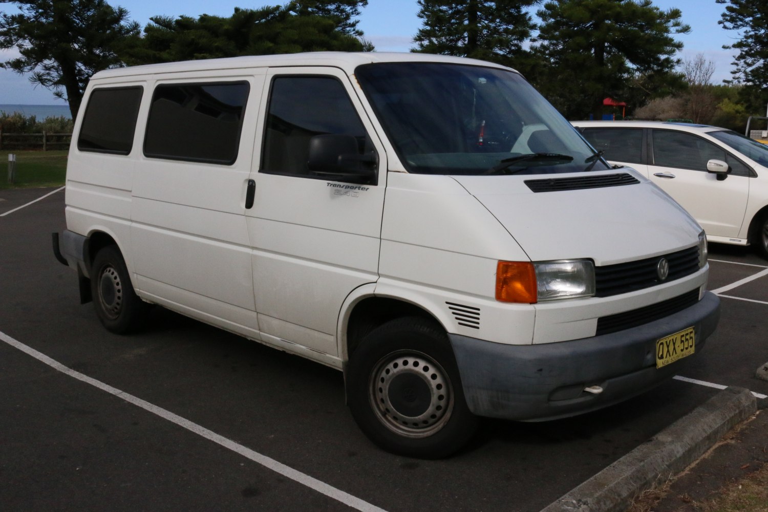 White boxy van front-side view with rectangular headlights and tinted windows