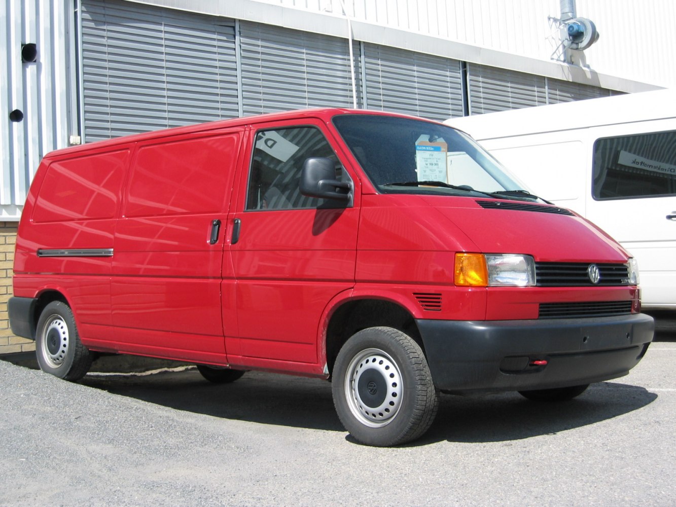Red panel van with sliding side doors and compact front design.