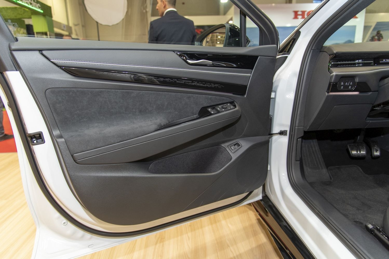 Interior door panel with controls, upholstery, and handle features.
