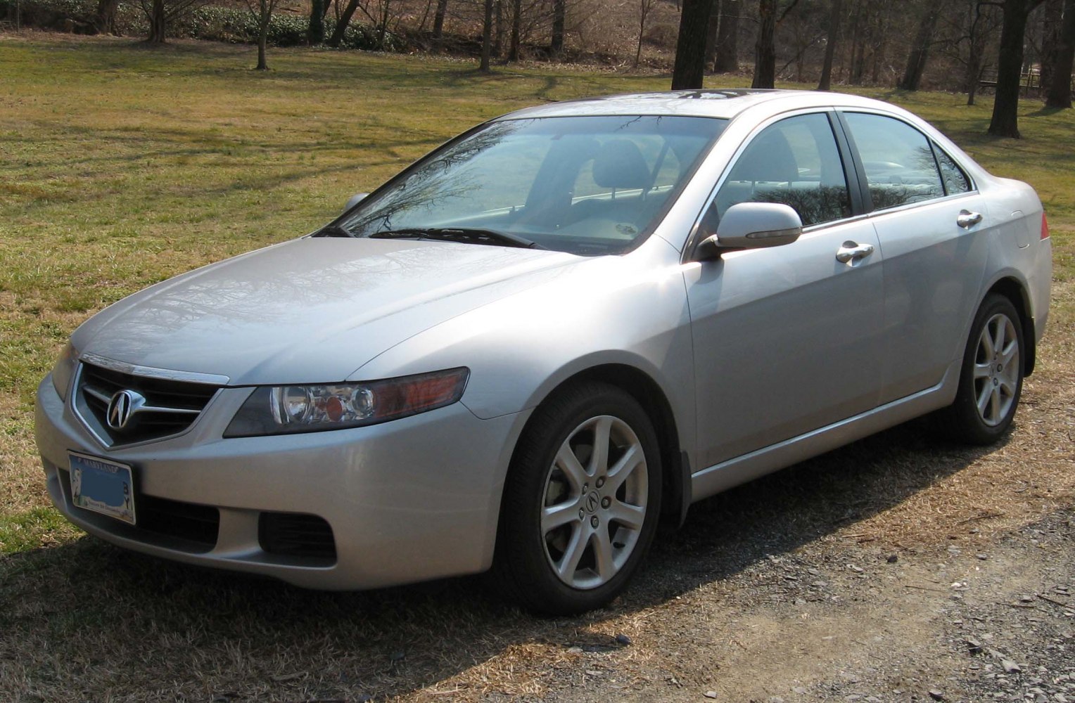 Front-side view of silver four-door sedan with alloy wheels.