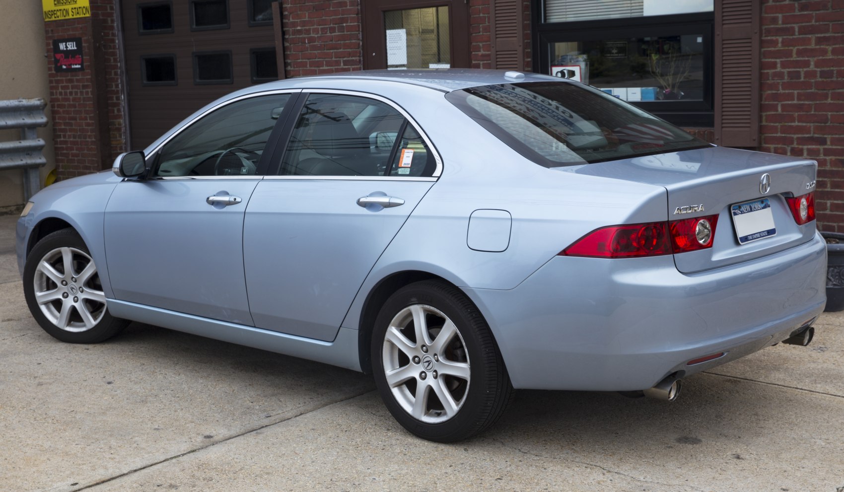 Rear-side view of light blue sedan with alloy wheels