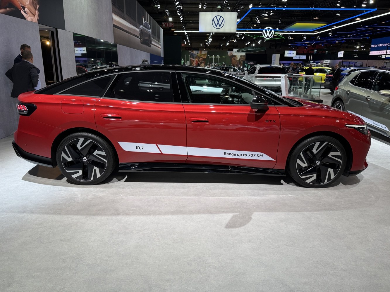 Side profile of red electric sedan with aerodynamic wheels and 707 km range