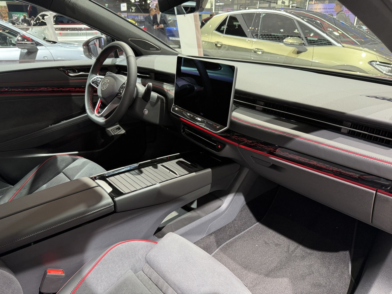 Modern car interior with large digital touchscreen and red accent stitching