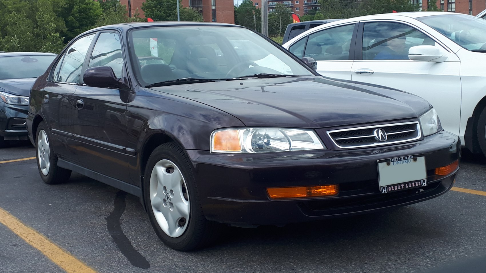 Front side view of compact sedan with headlights and alloy wheels