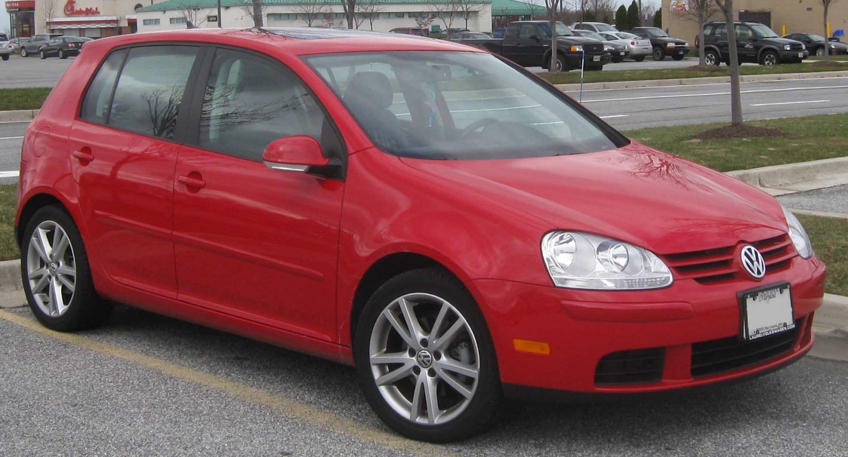 Red 5-door hatchback with alloy wheels and front side view