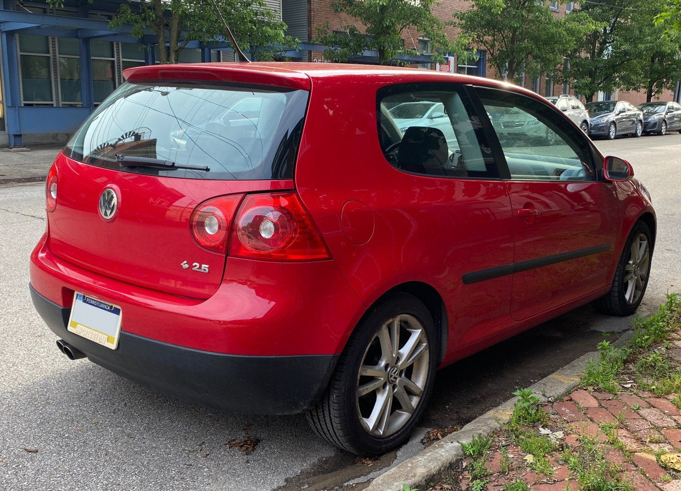 Rear view of a red 3-door hatchback with distinctive taillights and 2.5 engine badge