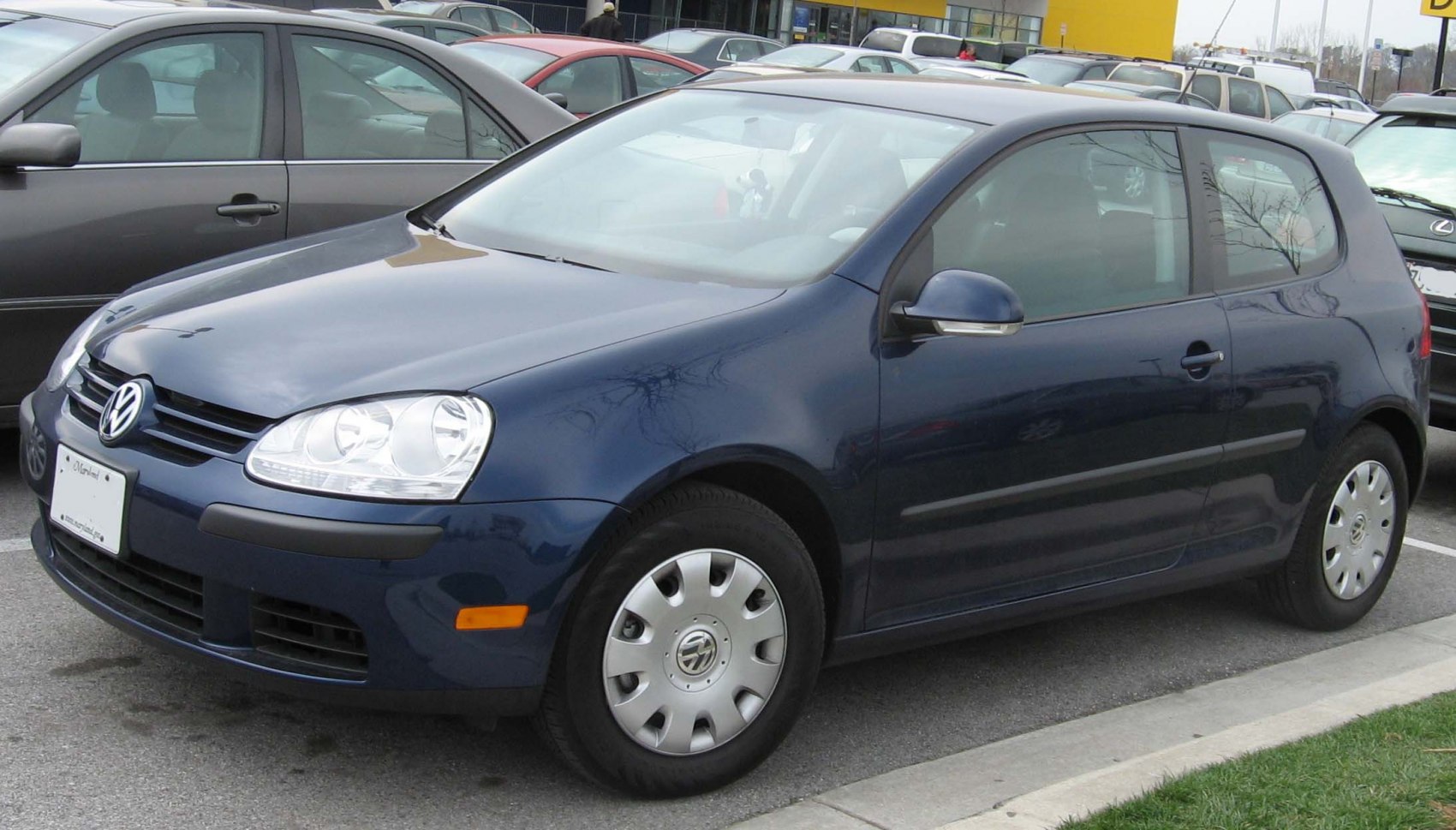 Front side view of a 3-door hatchback with rounded headlamps and simple hubcaps
