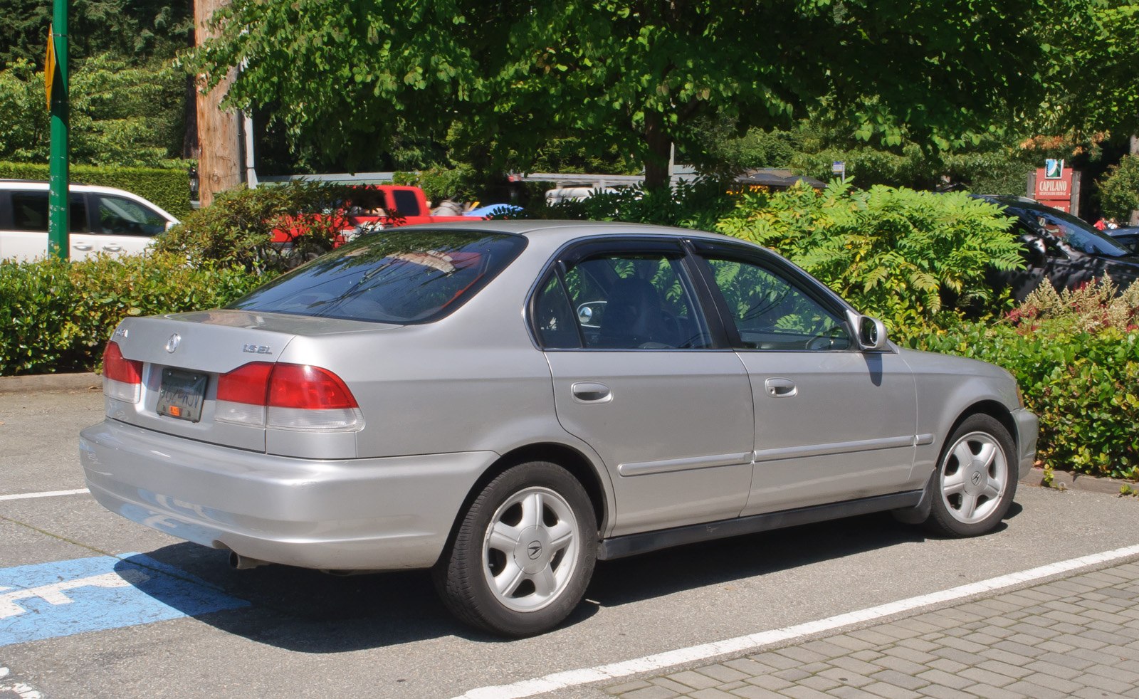 Silver sedan rear and side view parked outdoors