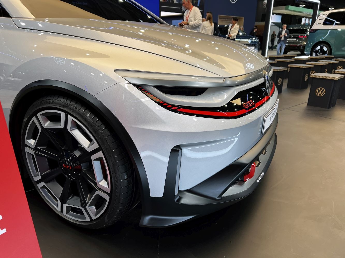 Sleek front headlight with red accents and geometric alloy wheel.